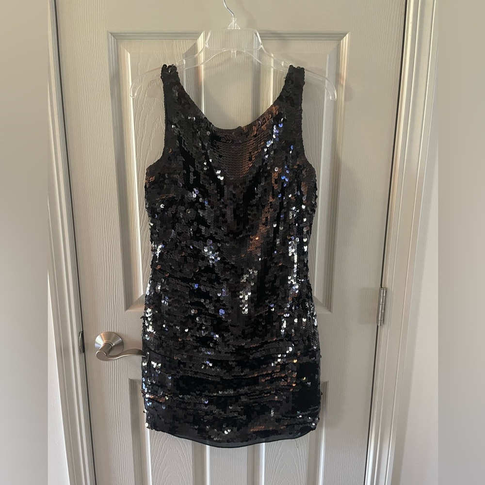 Short sleeveless black sequin mini dress.